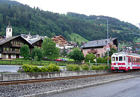 Triebwagen der AOMC vor der Kulisse des Ortes